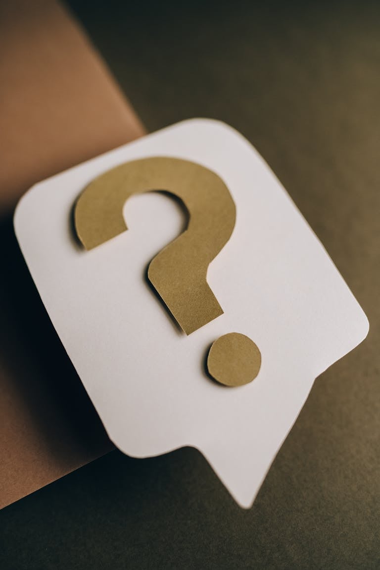 Artistic paper craft of a question mark symbol on a textured green surface. Ideal for conceptual projects.