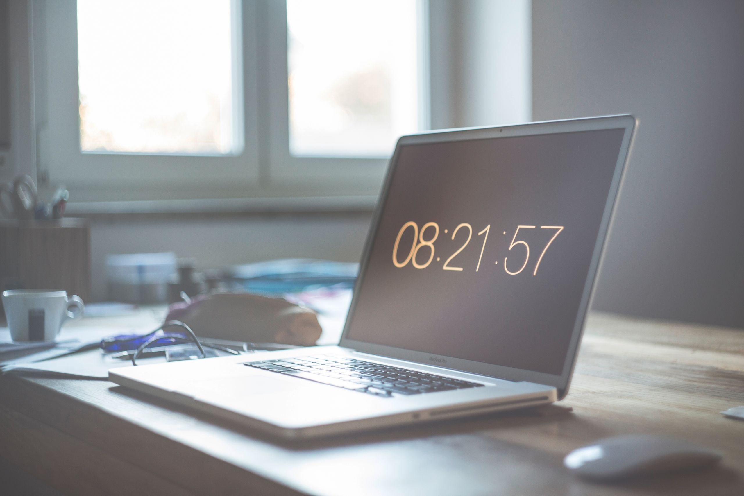 A serene workspace featuring a laptop with digital time display, perfect for productivity and focus.